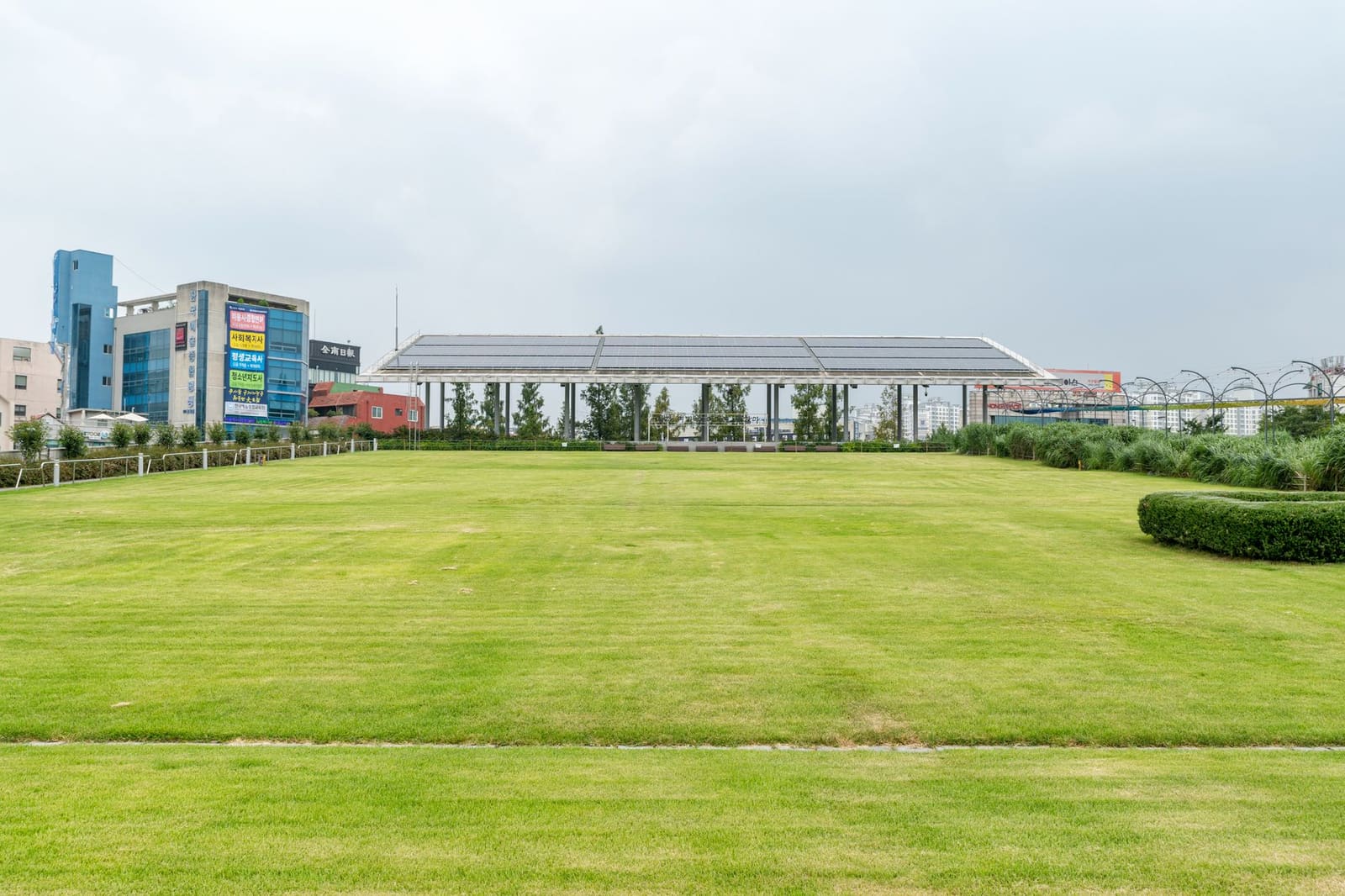 Zonnepanelen op een open overkapping aan de rand van een grasveld